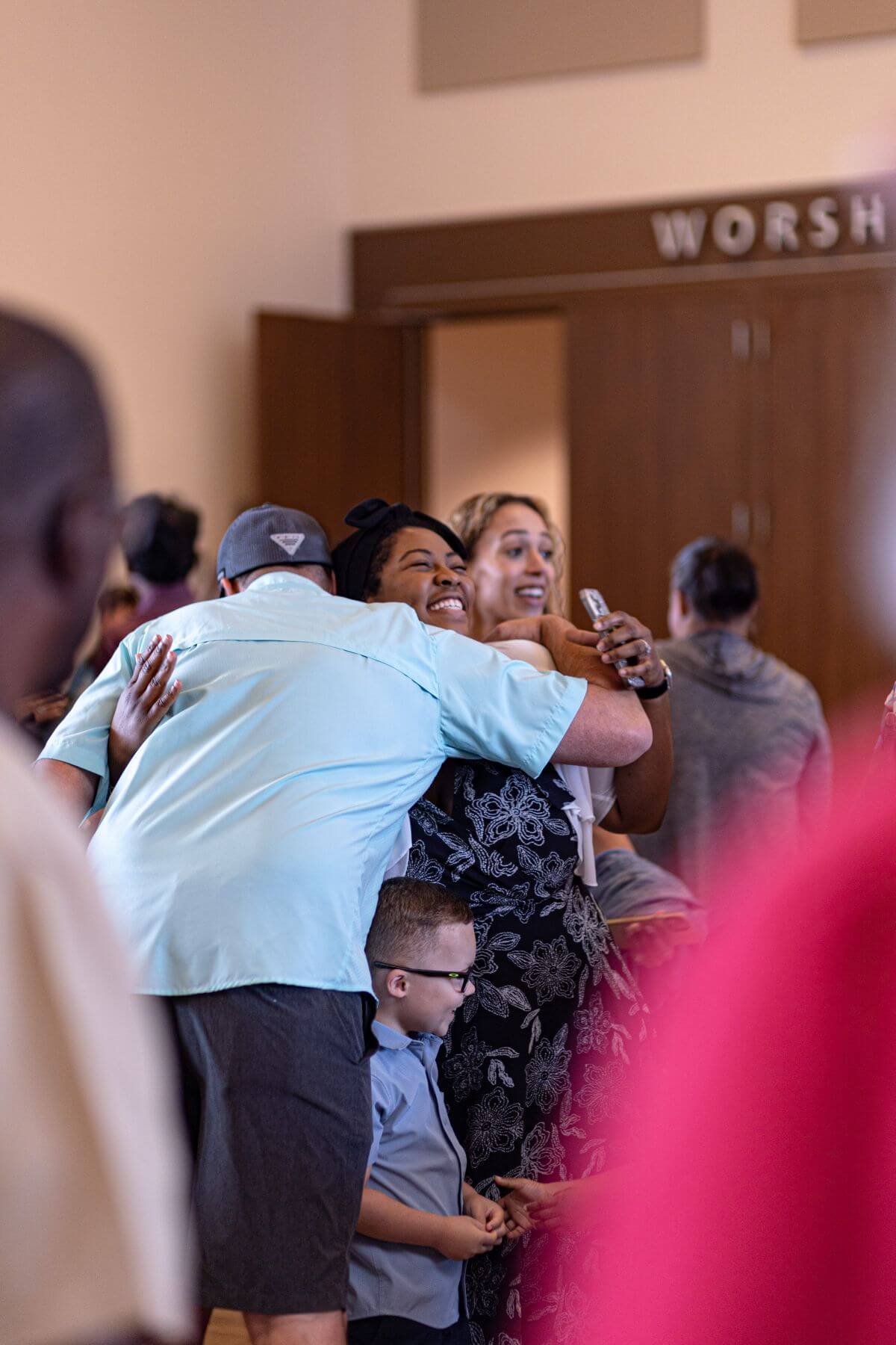 HFBC congregation members hugging during service.